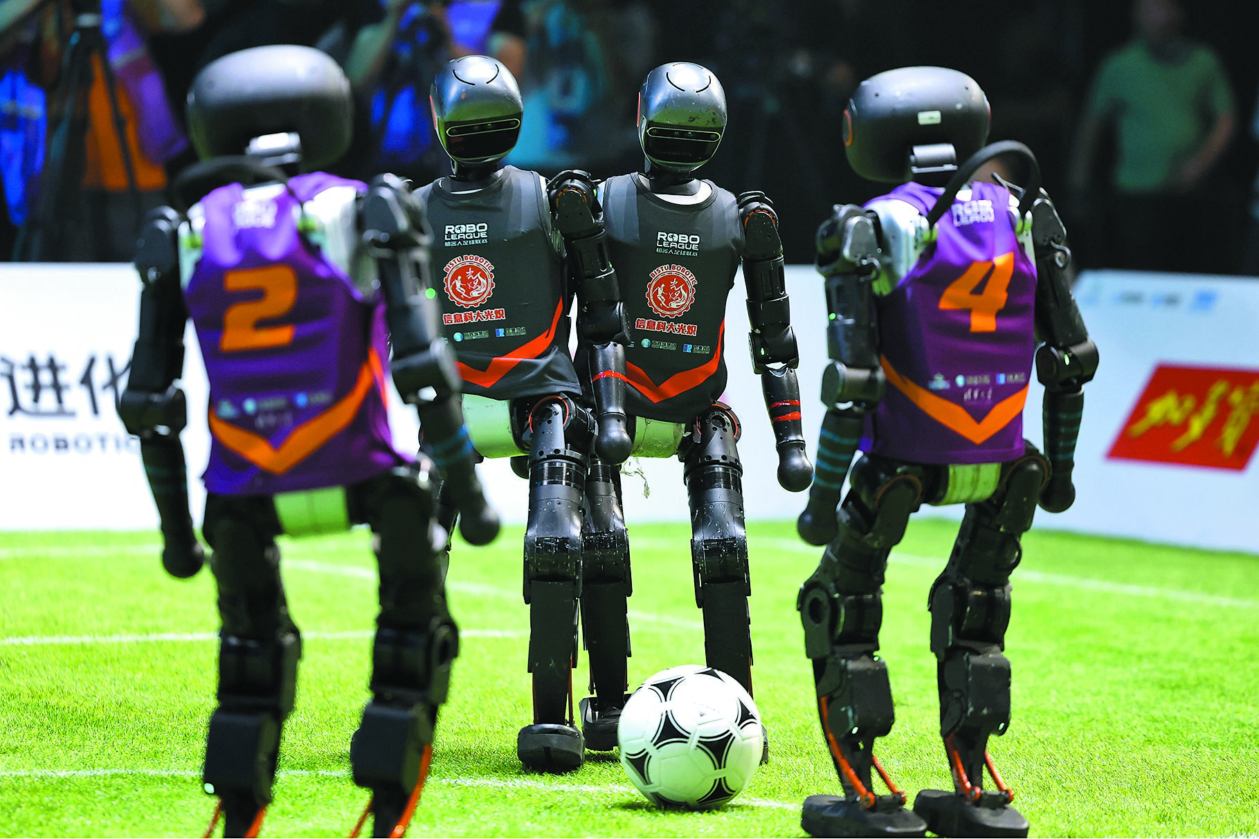 RoBoLeague機器人足球聯賽決賽階段比賽28日正式打響。圖為清華大學火神隊(紫)對戰北京信息科技大學Blaze光熾隊(黑)。(中新社) image
