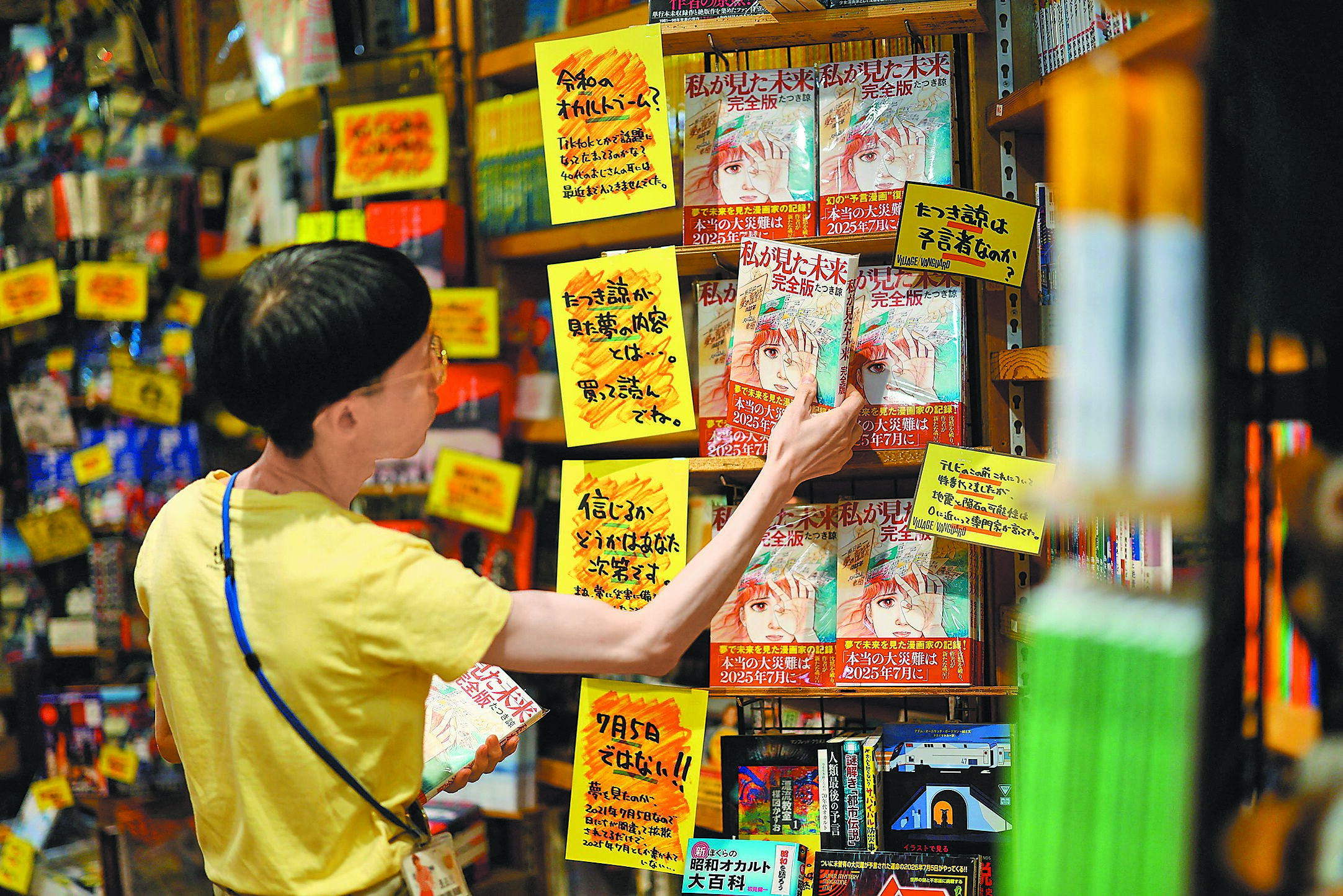 6月30日,東京一名書店工作人員將竜樹諒《我所看見的未來》擺放在書架上。(路透) image