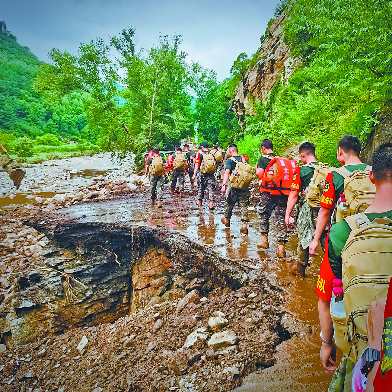 大陸華北各地暴雨肆虐成災,光是北京至少30人死亡,超過8萬人緊急撤離。圖為共軍與武警官兵前進災區救災。(新華社) image