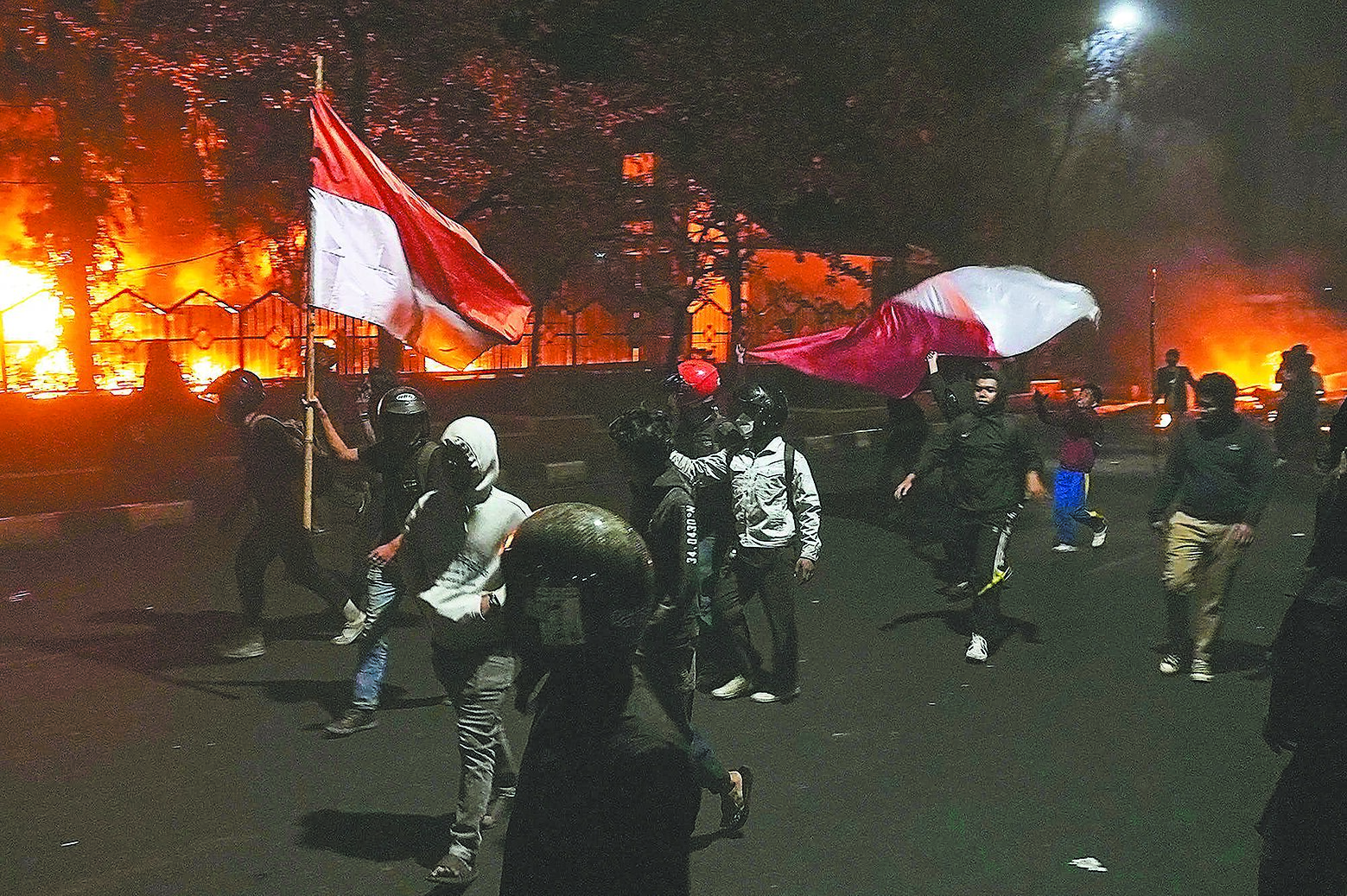 印尼抗議者與防暴警察發生衝突,當地議會大樓被大火吞沒。(美聯社) image