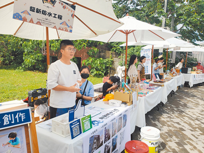 林鉦庭(左一)和妻子及孩子16日在斗六青創基地擺攤宣導他們創業的防水工程行生意,在一片清新小確幸的行業中特別凸顯。(周麗蘭攝) image