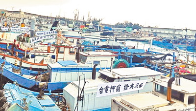 桃園永安漁港漁民指受三接外推方案及大潭電廠影響,去年漁獲量較7年前銳減,台電與中油對補償事宜推拖拉,多艘停在漁港內的漁船掛起抗議布條,醞釀農曆年後發起抗爭。(永安漁港討海人協會提供/呂筱蟬桃園傳真) image