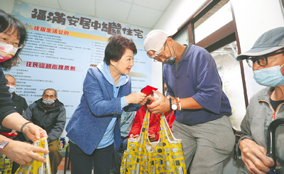 台中市長盧秀燕(左)26日到社會局臨時收容處所「福滿安居」探視街友,發送圍爐餐禮盒、小紅包及物資福袋,陪伴街友們提前溫馨過春節。(張妍溱攝) image