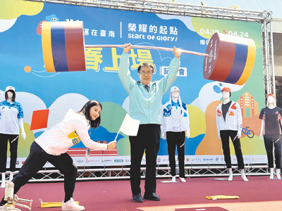 在台南柳營成長的「舉重精靈」方莞靈(左)指導市長黃偉哲(右)表演舉起道具舉重槓鈴的動作,贏得現場來賓如雷掌聲。(洪榮志攝) image