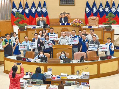新北市議會國民黨團書記長王威元9日帶領黨籍議員一同上台高喊「府會一條心、辦好世壯運」,期許世壯運圓滿成功。(高鈞麟攝) image