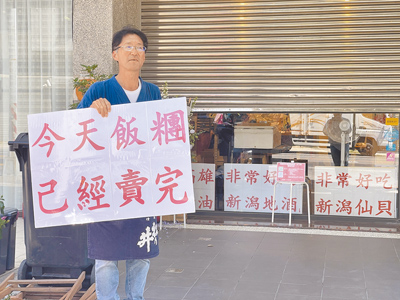 日籍老闆樋口先生靠著每日親自舉牌招攬客人,並堅持手作日式飯糰,逐漸累積人氣,但因租屋糾紛最後還是決定搬遷新地點重新開始。(丁治綱攝) image