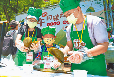 新北市蘆洲區公所為慶祝端午佳節,5月31日在蘆洲李氏古宅舉行「2025端午節三代同樂齊包粽」活動,參與者祖孫三代穿著可愛的圍裙及廚師帽,共同協力包粽。(姚志平攝) image