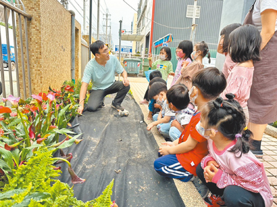 台中市8月起幼兒園大班必須配置1名幼教師,圖為南屯幼兒園園長陳議濃(左)與孩童熱情互動。(台中市府提供/陳淑娥台中傳真) image