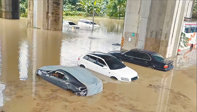 中央氣象署多次對南投縣發豪雨、雷雨特報,南投市貓羅溪溪水暴漲,附近國道3號高架橋下停車場淹水,來不及移車車輛成泡水車。(民眾提供/楊靜茹南投傳真) image