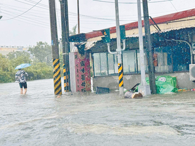 嘉義縣28日凌晨下起豪大雨,多個鄉鎮村落積淹水嚴重,民眾冒險涉水而行。(呂妍庭攝) image