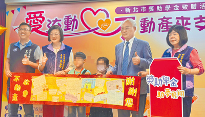 獲得獎學金的學生們手寫感謝卡,獻給新北市不動產開發商業同業公會理事長廖志鴻(右二),並與市議員王威元(左一)、社會局長李美珍(左二)及副局長吳淑芳(右一)合影。(張鎧乙攝) image