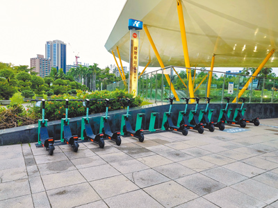 高雄市中央公園近日有業者設置共享電動滑板車供遊客租借,並導入「電子圍籬」機制,避免衍生交通亂象。(任義宇攝) image
