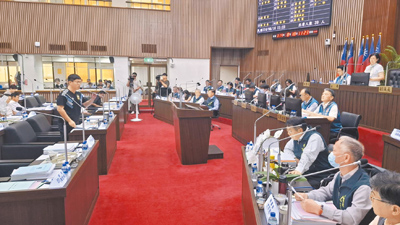 民進黨台南市議員周嘉韋(左邊站立者)在台南市議會臨時會閉幕前提臨時案要求普發現金。(程炳璋攝) image