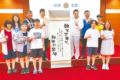 苗栗縣書法家黃太平(後排左三)連續3年榮獲日本公益財團法人武道館主辦的「全日本書初大展覽會國際書法比賽」特別賞。苗栗縣長鍾東錦(後排右三)25日特別表揚,期望各校能加強推廣書法社團。(謝明俊攝) image
