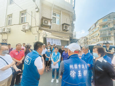 桃園龍潭土地糾紛,地主官司勝訴17日透過法院強制執行刨除柏油,住戶不滿地主喊價1坪要賣85萬元,在家門前綁白布條抗議,現場多方協議後暫緩執行。(呂筱蟬攝) image